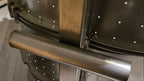 Close-up of a metal pot with a handle on a wooden surface