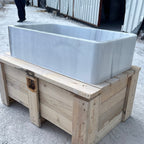Large white marble sink on wooden pallets outdoors