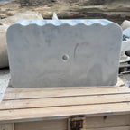 Marble basin on a wooden pallet with a mountainous landscape in the background